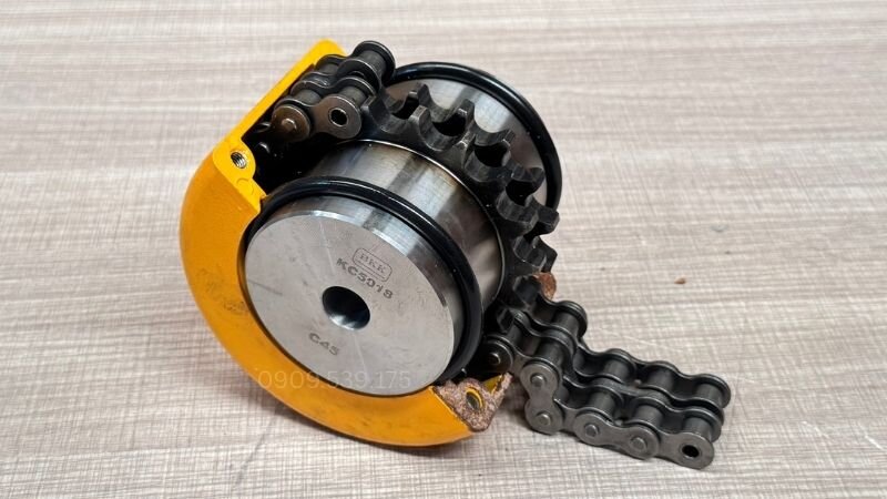 Khớp nối xích hoạt động dựa trên hai đĩa xích đồng tâm liên kết bằng sợi xích đôi giúp truyền mô-men xoắn trực tiếp và ổn định giữa hai trục.