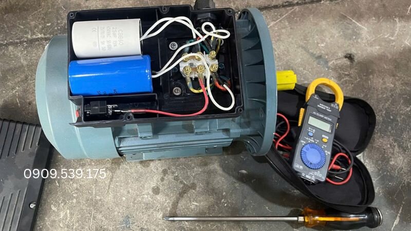 Đồng hồ vạn năng (VOM), pin DC 9V và nhãn dán để xác định cực tính cuộn dây motor.